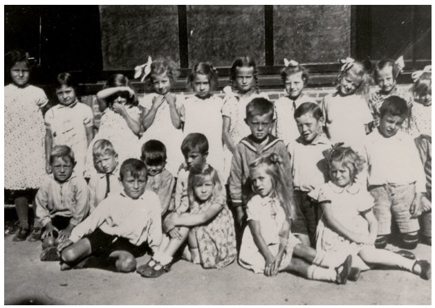 School met de Bijbel, Oost-Souburg 1933-1934. 
        De 2e klas poseert voor de muziektent op het Oranjeplein. 
        Op de onderste rij van l. naar r.: Adri Arendse, Janna Koole, Pietje Suurmond, Neeltje Dieleman. 
        Rij 2 knielend: Jan van de Driest, Jo Grijs, Lein Davidse, Kees Wisse, Piet de Visser, Gerrit Toerse, Willem Wisse, Jaap Pouwer. 
        Bovenste rij: Saar van Maldegem, Dina Dorleijn, Corrie Sturm, Jo Kaljouw, Leni Bevelander, Nellie Koppejan, Zoetje Tissink, Janna Brouwer, Betsie de Bruijn, Manna van Reeden.